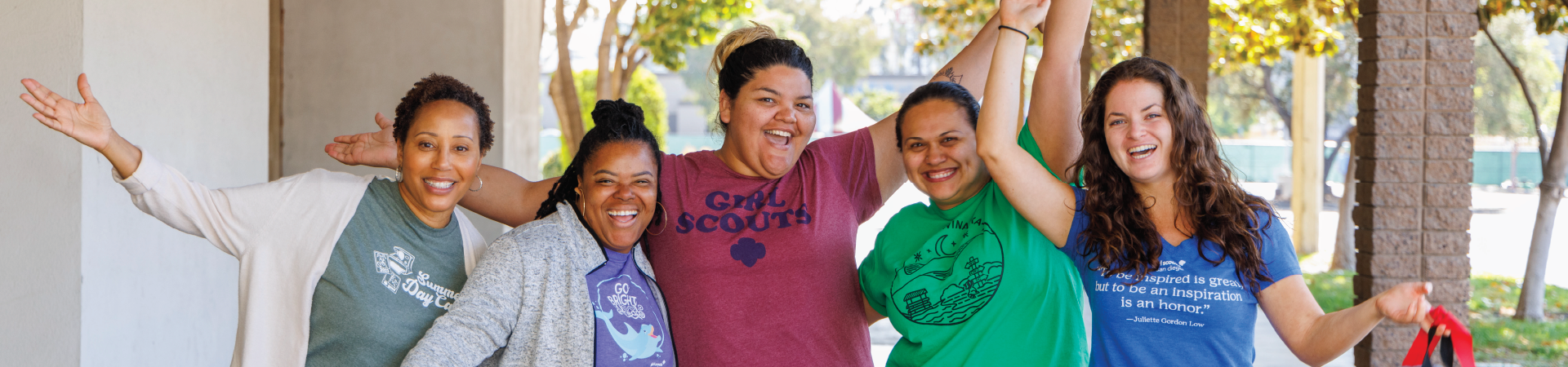  group of young girl scout alums smiling and talking to one another 